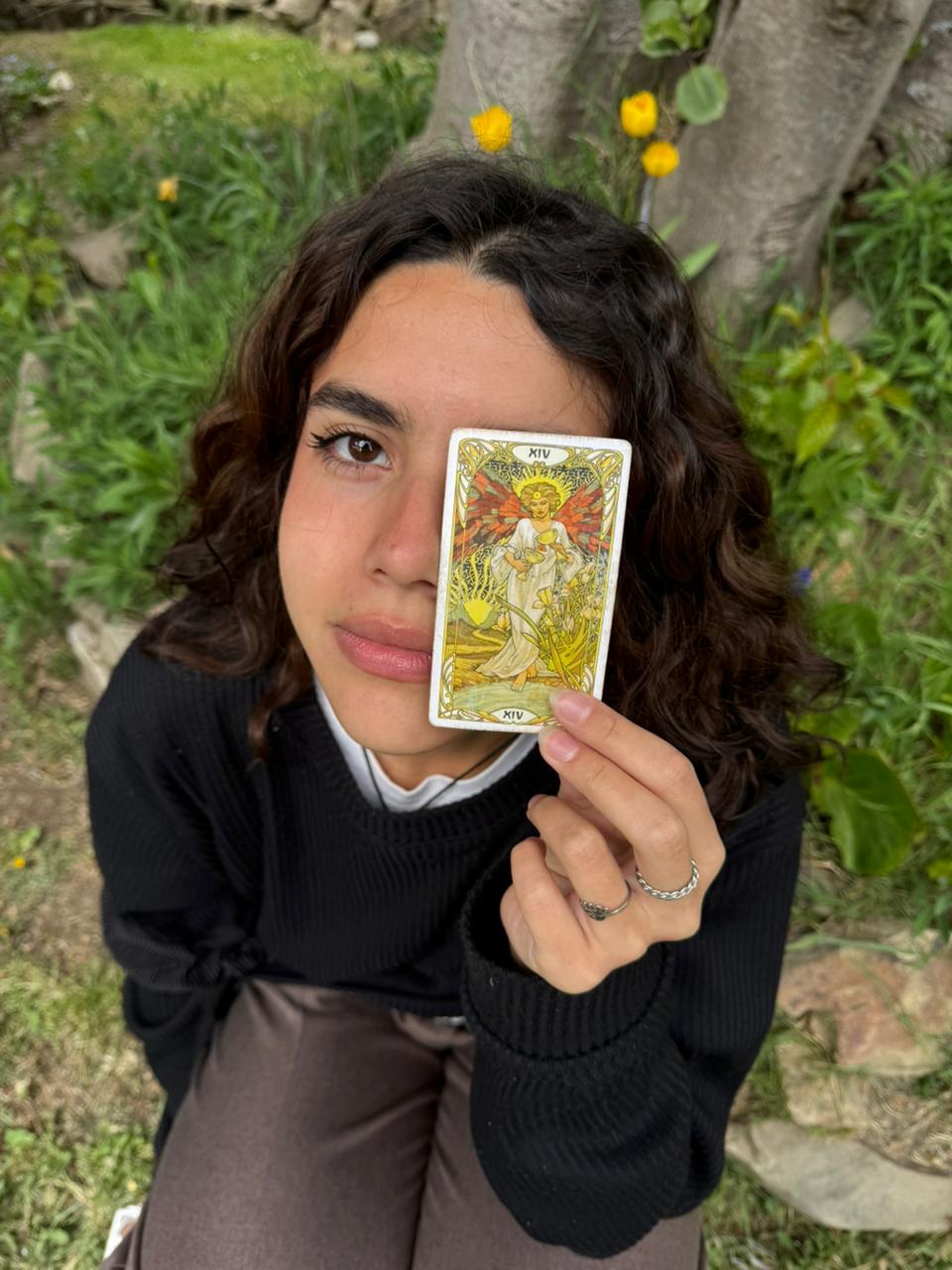 Romi, creadora de La Templanza del Tarot, sosteniendo la carta de La Templanza